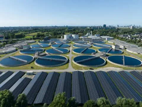 Een grote zuivering met op de voorgrond zonnepanelen.